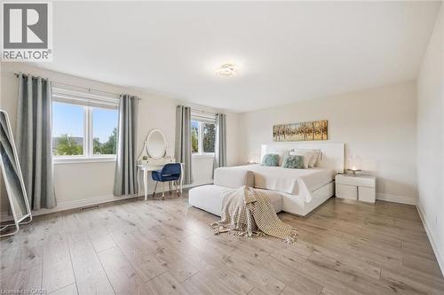 Bright room featuring multiple windows, wood-finish flooring, a white ceiling, and light-toned walls - 517 Topper Woods Crescent, Kitchener, ON 