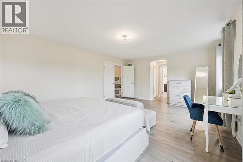 Wood-finish flooring throughout, light neutral wall tones, recessed lighting, and a walk-in closet with built-in shelving - 517 Topper Woods Crescent, Kitchener, ON 