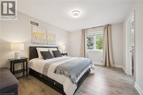 Wood-finish flooring with a white trim, a single window, and a flush mount ceiling light - 517 Topper Woods Crescent, Kitchener, ON 