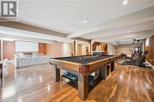 Expansive lower level featuring wood-finish flooring, recessed lighting, and a built-in projection screen - 517 Topper Woods Crescent, Kitchener, ON 