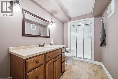 Wood-finish vanity with an integrated sink and light-toned countertop - 517 Topper Woods Crescent, Kitchener, ON 