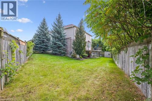 Expansive grassy yard with mature trees and a rear deck - 517 Topper Woods Crescent, Kitchener, ON 