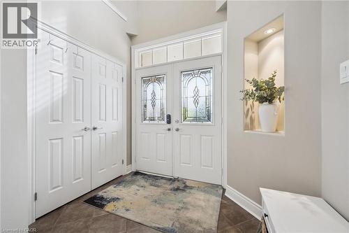 Double entry doors with decorative glass panels, transom window, recessed wall niche with lighting, and tiled flooring - 517 Topper Woods Crescent, Kitchener, ON 