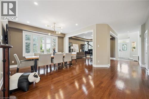 Hardwood flooring, recessed lighting, decorative chandelier, window shutters, and a transom window above the entry door - 517 Topper Woods Crescent, Kitchener, ON 