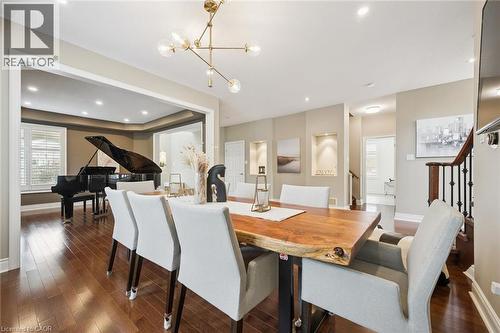Wood-finish flooring throughout, recessed lighting, decorative wall niches with accent lighting, and a modern chandelier - 517 Topper Woods Crescent, Kitchener, ON 