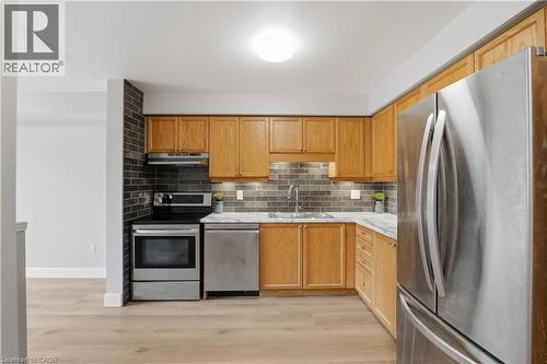 Wood-finish flooring, stainless steel appliances, marble-look countertops, subway tile backsplash, and wood cabinetry - 30 S Imperial Road Unit# 3, Guelph, ON 