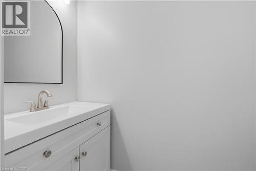White vanity with brushed nickel hardware, integrated sink, and an arched mirror - 30 S Imperial Road Unit# 3, Guelph, ON 