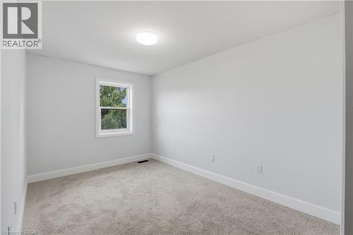 Neutral tone wall finish, white trim, light-colored carpeting, and a window with white casing - 30 S Imperial Road Unit# 3, Guelph, ON 