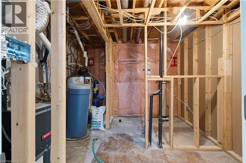Unfinished basement with exposed wood framing, visible plumbing, and a water softener system - 30 S Imperial Road Unit# 3, Guelph, ON 