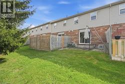 Private fenced backyard featuring a patio area, sliding glass door access, and a manicured lawn - 