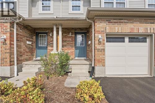 Brick and siding exterior with concrete steps, covered entry, and integrated garage featuring transom windows - 30 S Imperial Road Unit# 3, Guelph, ON 
