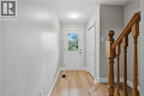 Entryway featuring wood-finish flooring, a white paneled door with windowpanes, a recessed ceiling light, and a built-in closet - 30 S Imperial Road Unit# 3, Guelph, ON 