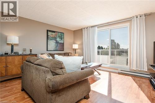 Wood-finish flooring, sliding glass door to exterior, textured ceiling, and neutral wall tones - 71 Vanier Drive Unit# 310, Kitchener, ON 