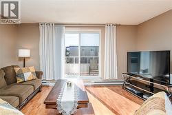Hardwood-finish flooring, sliding glass door leading to an outdoor balcony, and neutral wall tones - 