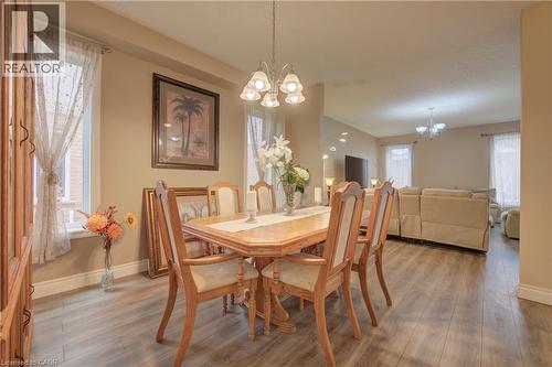 Open-concept interior featuring wood-finish flooring, recessed lighting, and a chandelier-style light fixture - 78 Stuckey Avenue, Baden, ON 