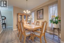 Dining area featuring wood-finish flooring, two window openings, and a chandelier lighting fixture - 