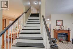 Staircase featuring dark treads with white risers, white balusters, and a dark wood handrail - 
