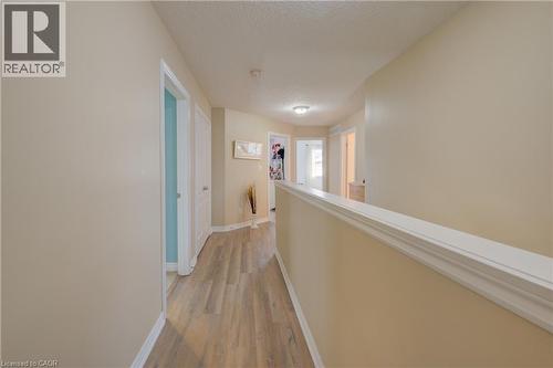 Hallway featuring wood-finish flooring, neutral wall paint, white trim, and recessed lighting - 78 Stuckey Avenue, Baden, ON 