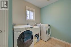 Laundry area with tiled flooring, a utility sink, and a single window - 