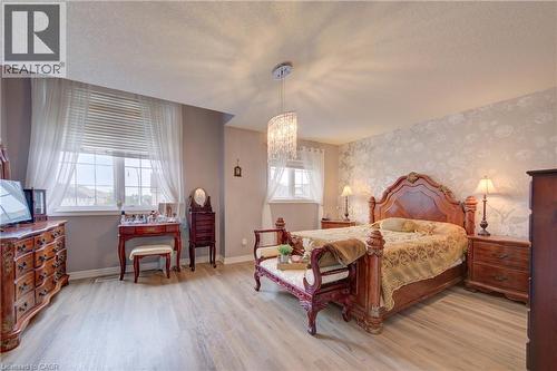 Wood-finish flooring, accent wall with patterned wallpaper, double-door entry, recessed lighting, and a chandelier fixture - 78 Stuckey Avenue, Baden, ON 