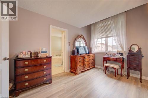 Wood-finish flooring, neutral wall tones, window with horizontal blinds and sheer drapery, recessed lighting, and a doorway opening to a bathroom with a built-in tub - 78 Stuckey Avenue, Baden, ON 