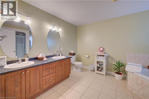 Double vanity with wood-finish cabinetry, dual sinks, and two  mirrors - 78 Stuckey Avenue, Baden, ON 