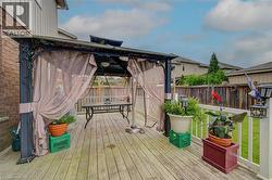 Expansive wood-finish deck with a built-in gazebo and privacy screens - 