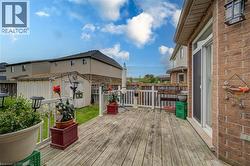 Expansive wood deck with white railing, brick exterior, and direct access to the interior - 