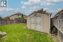 Expansive lawn area featuring a wooden storage shed, wood fence - 