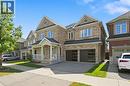 Stone and brick exterior with a covered front porch, a two-car garage, and multiple gabled rooflines - 3198 Tim Dobbie Drive, Burlington, ON 