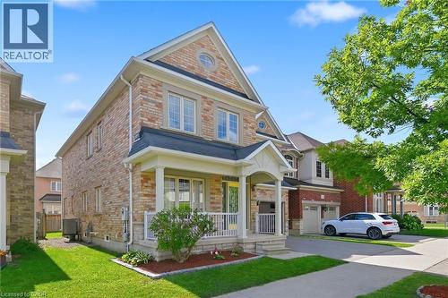 Brick and stone exterior with a covered front porch and white railings - 3198 Tim Dobbie Drive, Burlington, ON 