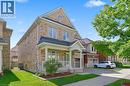 Brick and stone exterior with a covered front porch and white railings - 3198 Tim Dobbie Drive, Burlington, ON 
