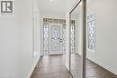Foyer with tiled flooring, a decorative front entry door, two sidelight windows, and mirrored sliding closet doors - 3198 Tim Dobbie Drive, Burlington, ON 