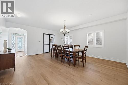 Wood-finish flooring throughout, transom window with decorative glass, recessed lighting, and a chandelier - 3198 Tim Dobbie Drive, Burlington, ON 