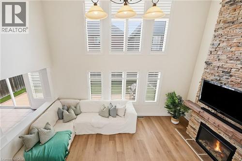 Soaring ceiling with high windows, stone-clad fireplace, wood mantel, and wood-finish flooring - 3198 Tim Dobbie Drive, Burlington, ON 