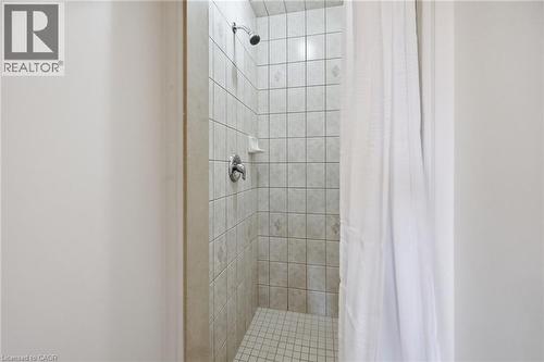 Tiled shower enclosure featuring a wall-mounted showerhead, chrome fixtures, and a corner soap dish - 3198 Tim Dobbie Drive, Burlington, ON 