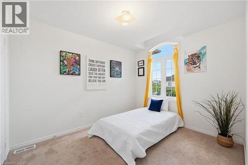 Arched window with gridded panes, white painted walls, and light brown carpeting - 3198 Tim Dobbie Drive, Burlington, ON 