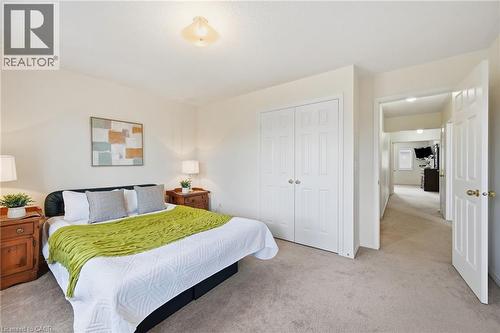 Neutral wall color, wall-to-wall carpeting, recessed ceiling light fixture, white bi-fold closet doors, and a paneled interior door - 3198 Tim Dobbie Drive, Burlington, ON 