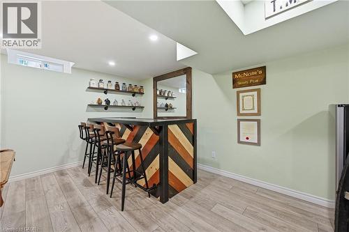 Built-in bar with chevron wood-finish paneling and dark countertop - 3198 Tim Dobbie Drive, Burlington, ON 