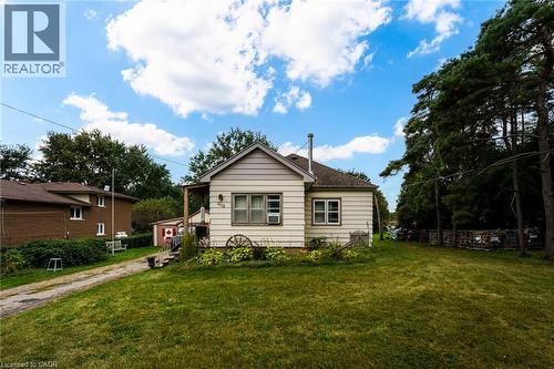 Single-story residence featuring light-colored siding, a covered porch entry, and multiple windows - 1412 Old York Road, Burlington, ON 