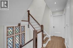 Wood-finish flooring, recessed lighting, and a white paneled door - 