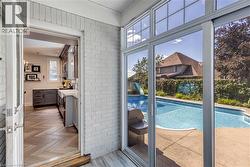 Swimming pool with concrete surround, framed by sliding glass doors with transom windows - 