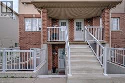 Brick facade, concrete stairs, white railings, covered entry, multiple entrances - 