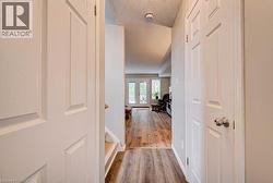 Wood-finish flooring throughout, white paneled doors, and recessed lighting - 