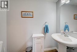 Pedestal sink with chrome faucet, wall-mounted mirror, and overhead lighting - 