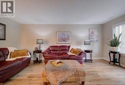 Light wood-finish flooring, neutral wall tones, and white window blinds - 