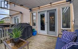 Wood-finish deck with a partial overhead shade structure and vinyl siding exterior - 