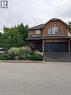 Brick exterior with an attached two-car garage, asphalt driveway, and mature landscaping - 5383 Haldimand Crescent, Burlington, ON 