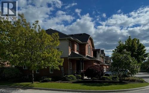 Brick facade residence with dark shingle roofing, mature trees, and landscaped grounds - 5383 Haldimand Crescent, Burlington, ON 