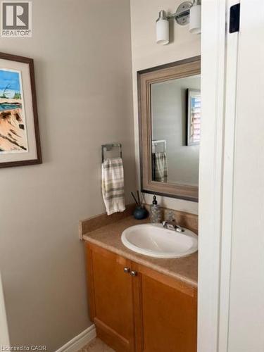 Vanity featuring wood-finish cabinetry, a built-in sink, and a framed mirror - 5383 Haldimand Crescent, Burlington, ON 